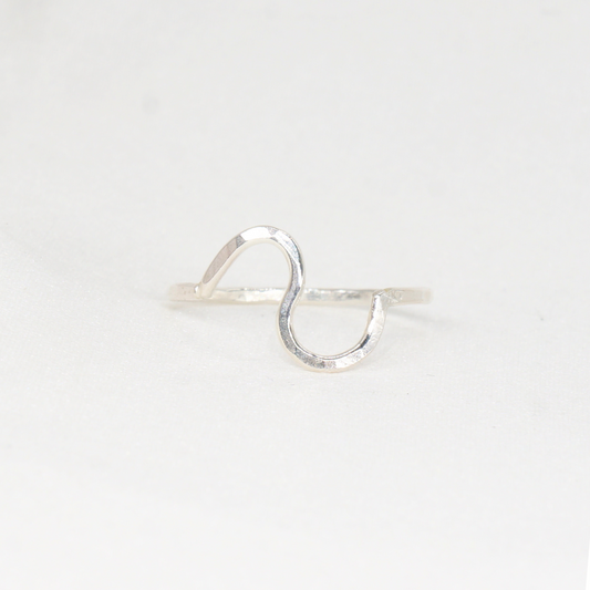 A silver ring with a wavy band and hammered texture.