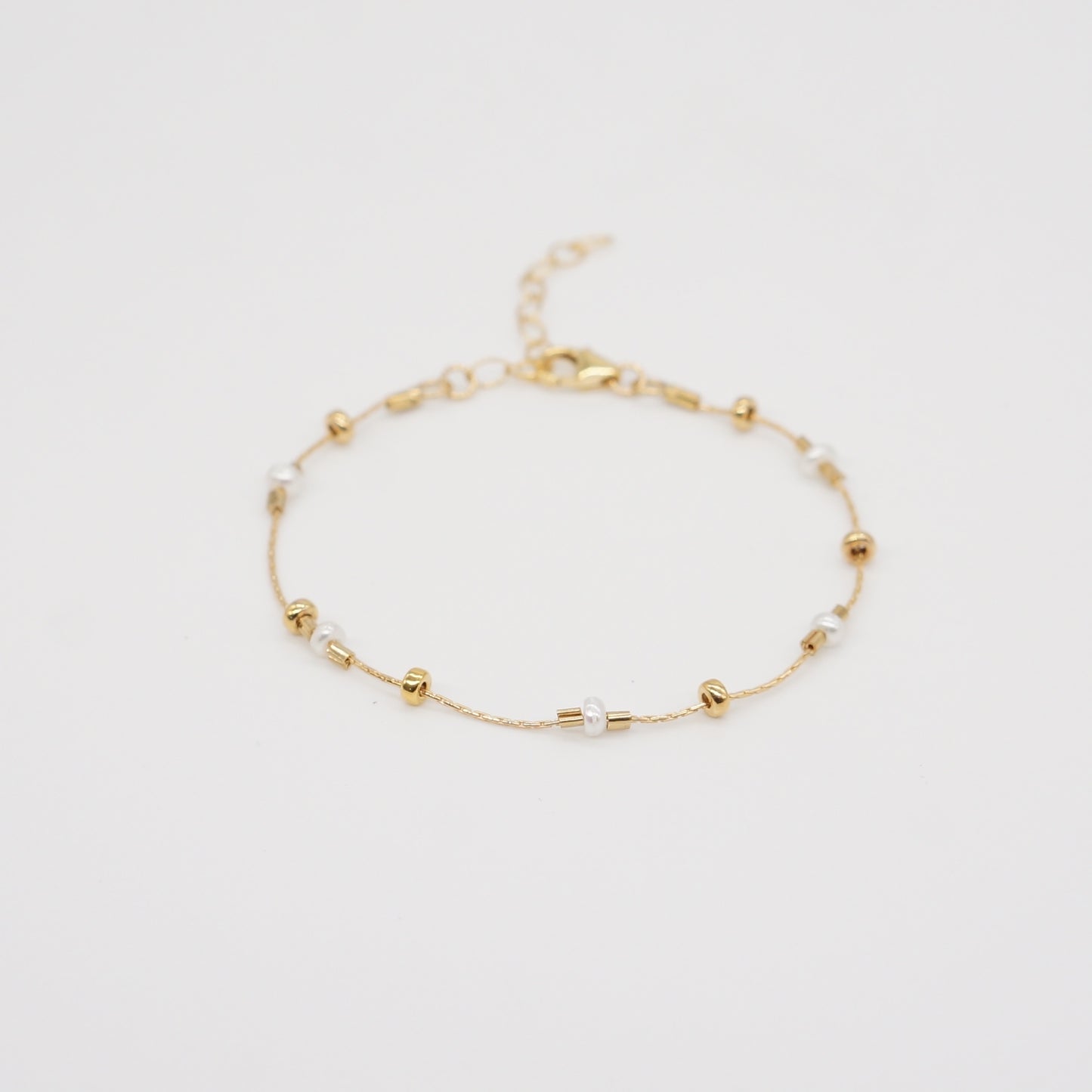 A dainty take on a pearl bracelet. Gold beads float freely in between dainty pearls.   1" extender 14k gold fill  made in Los Angeles  pearls vary in shape and size