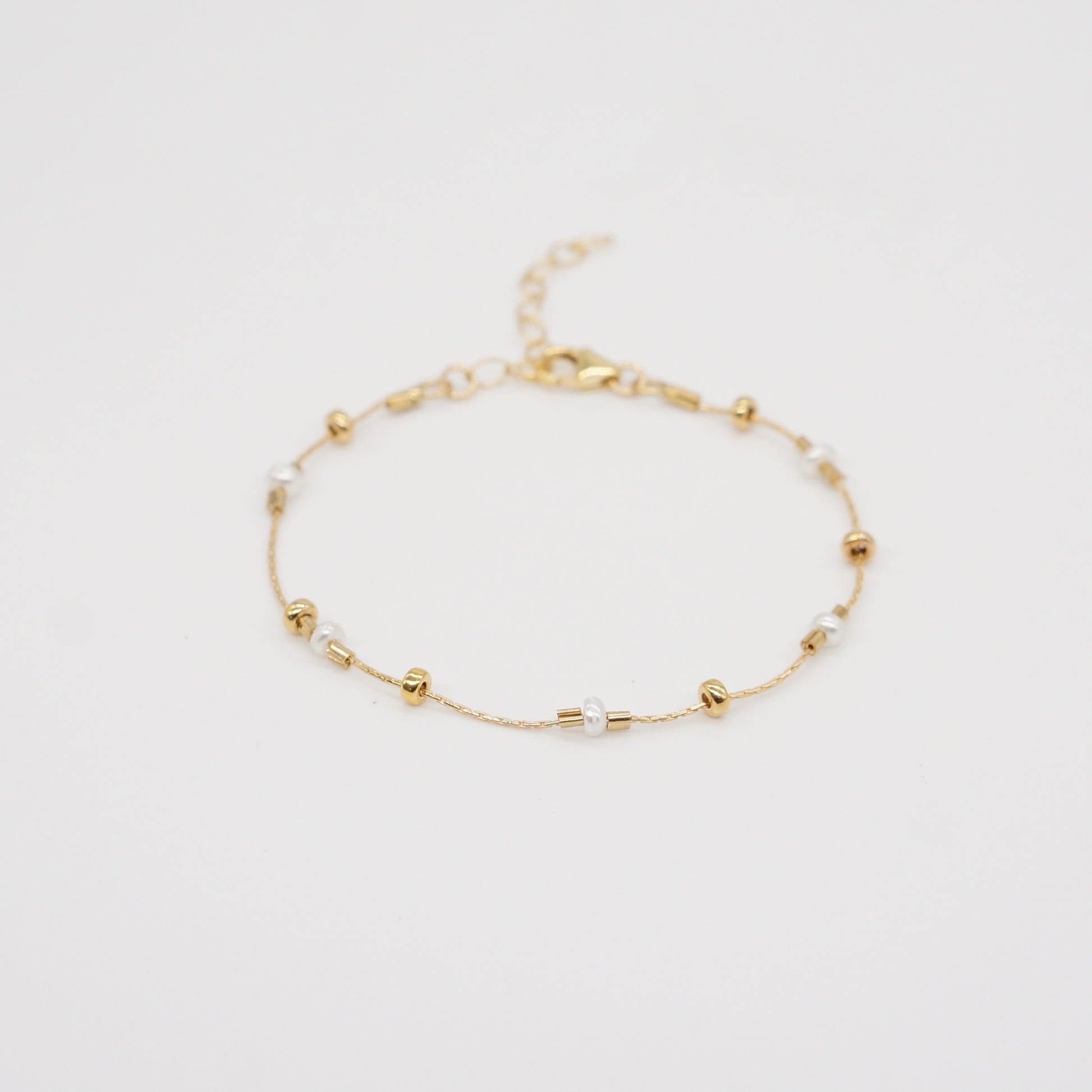 A dainty take on a pearl bracelet. Gold beads float freely in between dainty pearls.   1" extender 14k gold fill  made in Los Angeles  pearls vary in shape and size