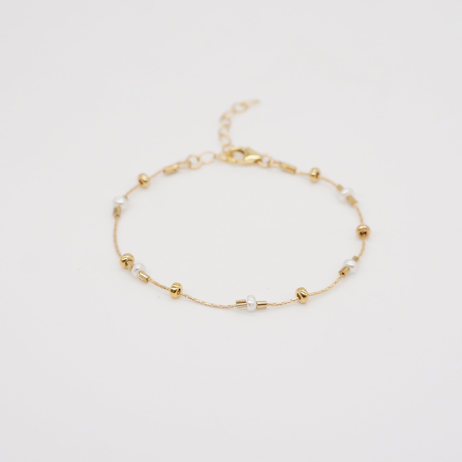 A dainty take on a pearl bracelet. Gold beads float freely in between dainty pearls.   1" extender 14k gold fill  made in Los Angeles  pearls vary in shape and size