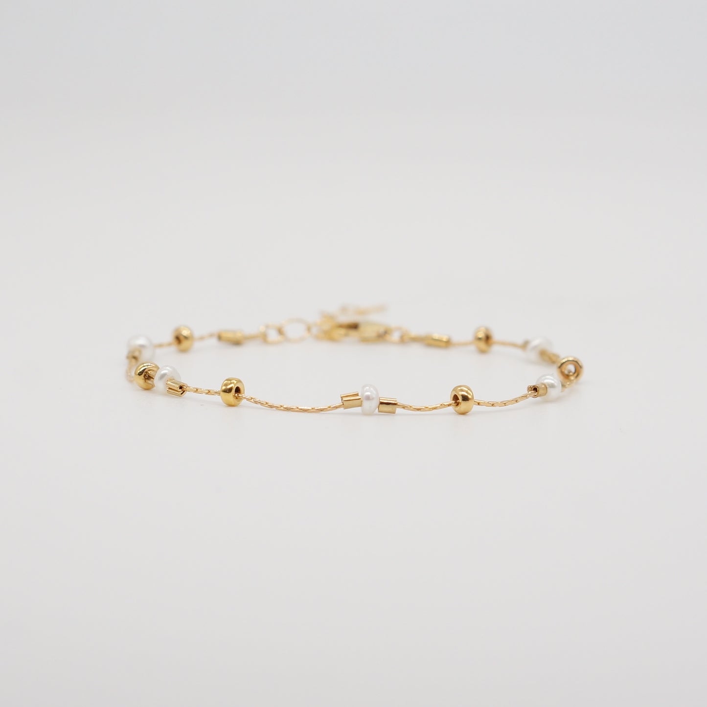 A dainty take on a pearl bracelet. Gold beads float freely in between dainty pearls.   1" extender 14k gold fill  made in Los Angeles  pearls vary in shape and size