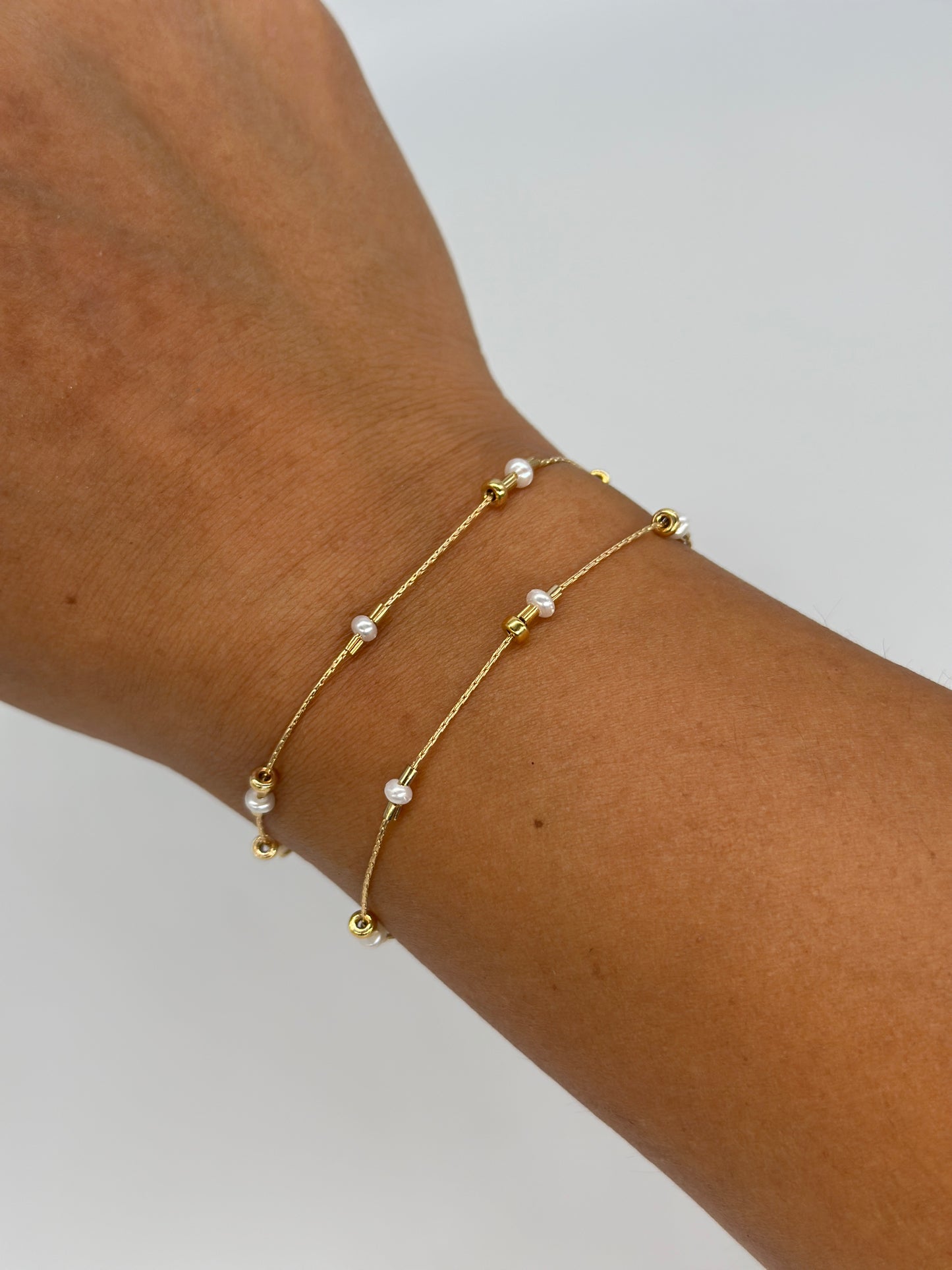 A dainty take on a pearl bracelet. Gold beads float freely in between dainty pearls. 1" extender 14k gold fill made in Los Angeles pearls vary in shape and size
