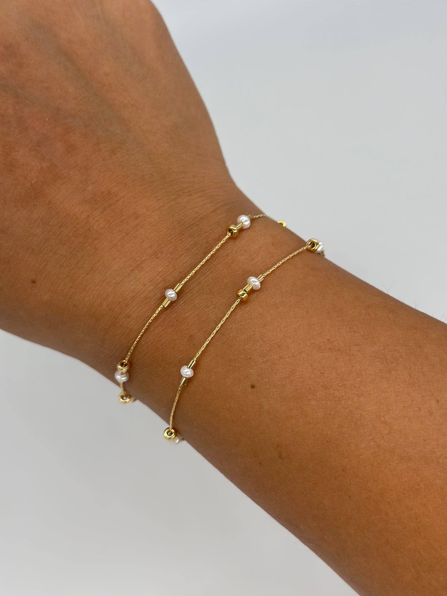 A dainty take on a pearl bracelet. Gold beads float freely in between dainty pearls.   1" extender 14k gold fill  made in Los Angeles  pearls vary in shape and size